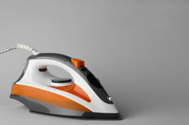 Açık gri arka planda modern bir ütü, metin için boşluk. Ev aletleri