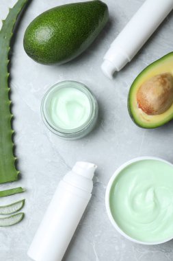 Flat lay composition with jars of cream on marble background