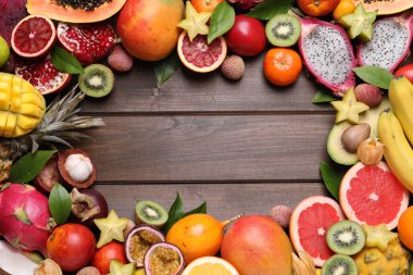 Ahşap zemin üzerinde farklı egzotik meyveler çerçevesi, düz yatıyordu. Metin için boşluk