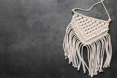 Stylish beige macrame on grey table, top view. Space for text