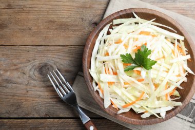 Fresh cabbage salad served on wooden table, flat lay