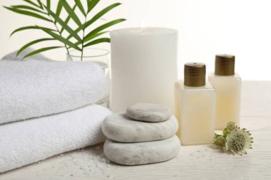 Beyaz ahşap masadaki spa taşlarıyla kompozisyon