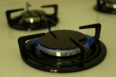 Modern sobanın gaz ocağı, yanan mavi alev, yakın çekim.