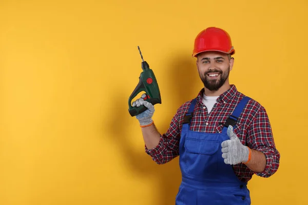 Young Worker Uniform Power Drill Yellow Background Space Text — Fotografia de Stock