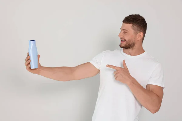 Handsome Young Man Holding Bottle Shampoo White Background — 스톡 사진