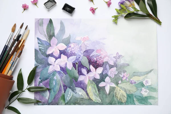 Flat lay composition with watercolor paints and floral picture on white background