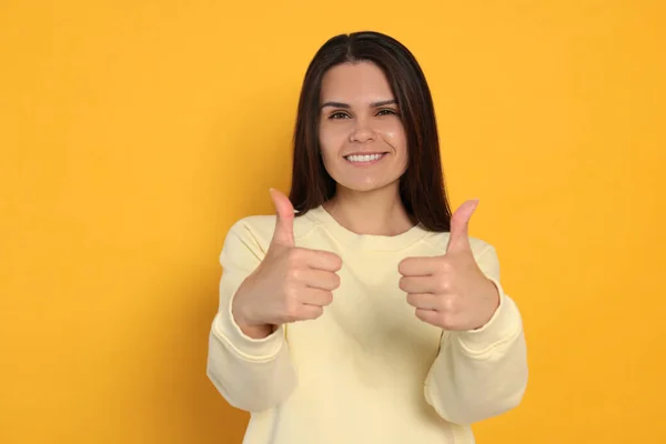 Young Woman Showing Thumbs Orange Background — Zdjęcie stockowe