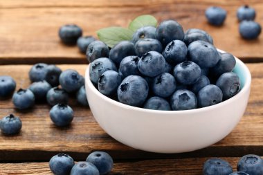 Tasty fresh blueberries on wooden table, closeup