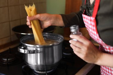 Mutfakta fırında spagetti pişiren kadın, yakın plan.