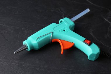 Hot glue gun with stick on dark grey table