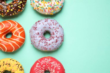 Turkuaz arka planda nefis jöleli donutlar, düz konum. Metin için boşluk