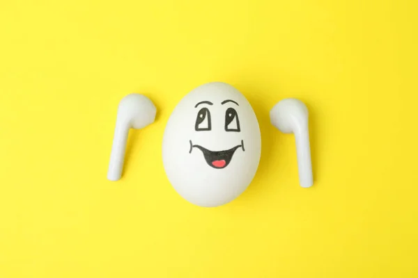 Egg Drawn Happy Face Earbuds Yellow Background Flat Lay — Stockfoto