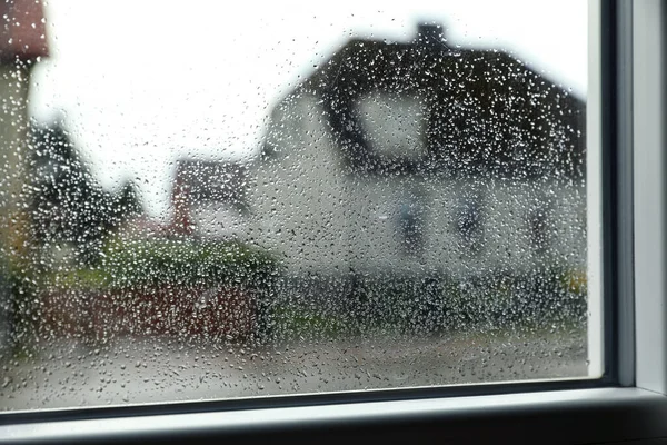 Blurred view of city street from window on rainy day