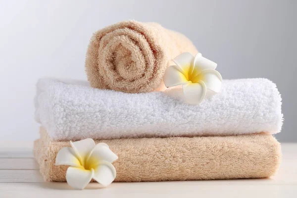 Closeup View Soft Folded Towels Plumeria Flowers White Wooden Table —  Fotos de Stock