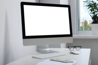 Workplace with modern computer and smartphone on white table. Mockup for design