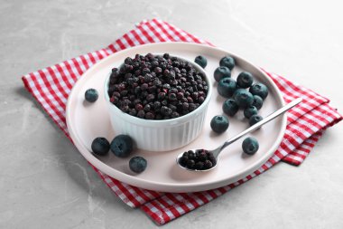 Freeze dried and fresh blueberries on light grey table