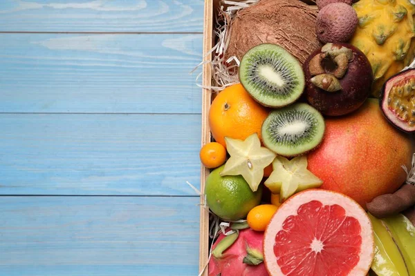 Frutas Tropicais Diferentes Caixa Fundo Madeira Azul Vista Superior Espaço — Fotografia de Stock