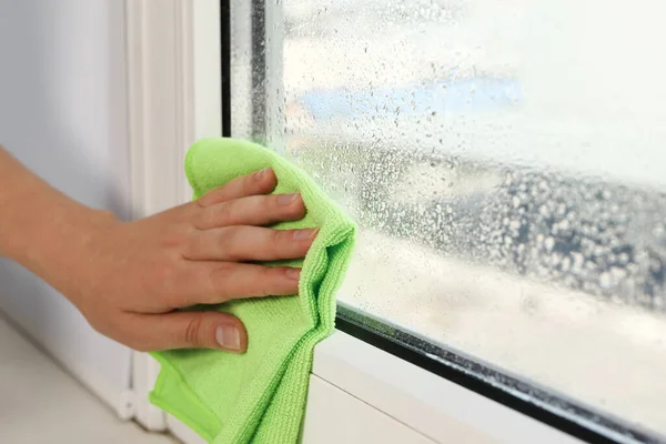 Woman Wiping Window Glass Drops Condensate Indoors Closeup — Stockfoto