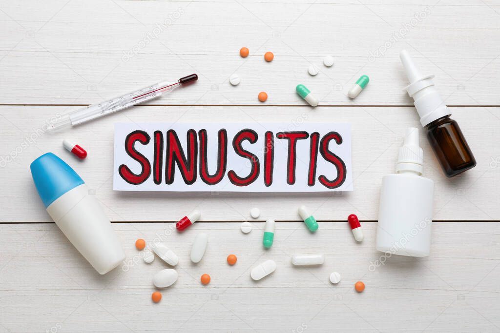 Card with word SINUSITIS, thermometer and different drugs on white wooden background, flat lay