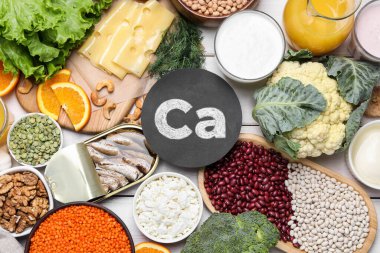 Beyaz ahşap masada yüksek kalsiyum içeren doğal besin seti.