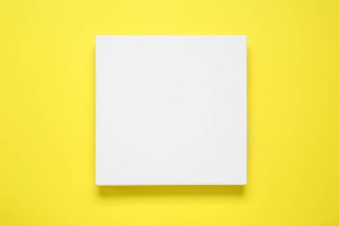 Blank canvas on yellow background, top view. Space for design