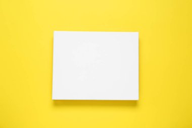 Blank canvas on yellow background, top view. Space for design
