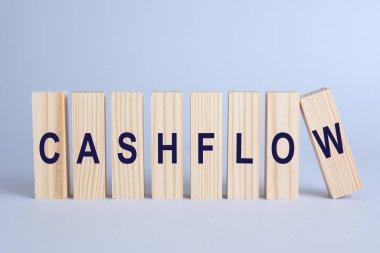 Wooden blocks with phrase Cash FLow on light grey background