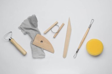 Set of clay modeling tools on white background, flat lay