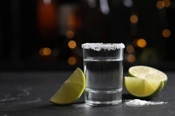 Mexican Tequila shot with lime slices and salt on bar counter