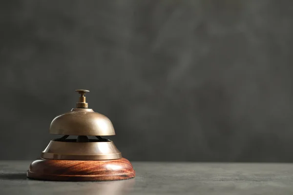 Hotel service bell on grey table. Space for text