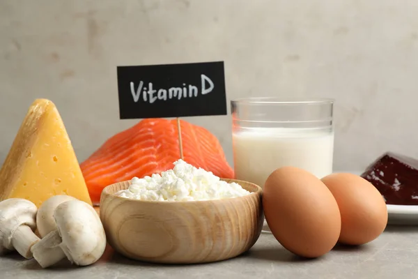 Paper with phrase VITAMIN D and fresh products on light table