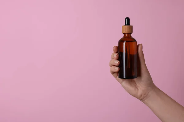 Жінка Тримає Пляшку Косметичного Продукту Рожевому Тлі Крупним Планом Простір — стокове фото