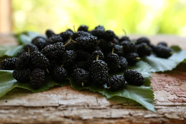 Heap Delicious Ripe Black Mulberries Green Leaves Wooden Table Blurred — Stock Photo, Image