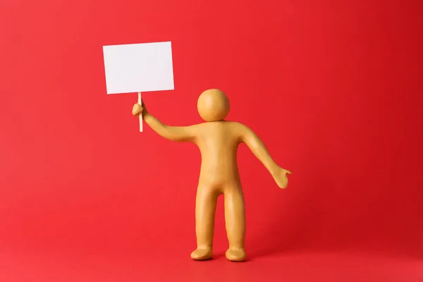 Human Figure Made Yellow Plasticine Holding Blank Sign Red Background — Φωτογραφία Αρχείου