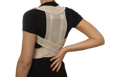 Closeup view of woman with orthopedic corset on white background