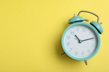 Sarı arkaplandaki alarm saati, metin için yeri olan üst görünüm. Okul zamanı.