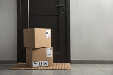 Girişteki paspasın üzerinde karton kutular var. Paket teslimat servisi
