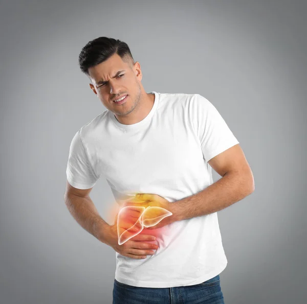 Man suffering from liver pain on grey background