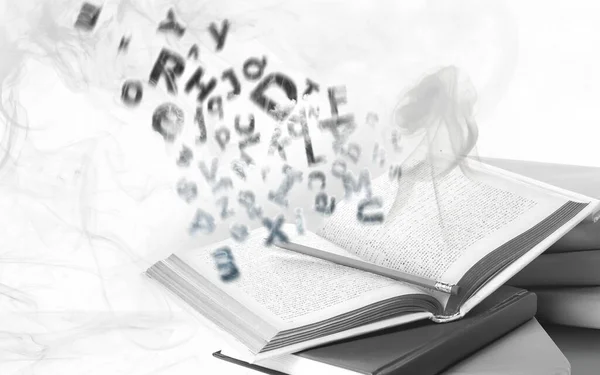 Open book with flying letters on white background. Dyslexia concept