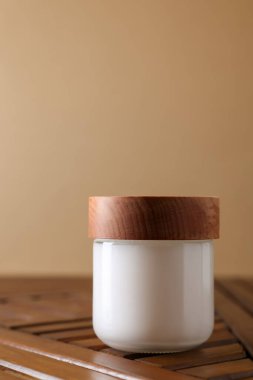 Jar of luxury cream on wooden table, space for text