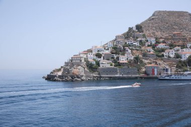 Güzel bir deniz manzarası, tekneleri ve kıyı kenti var.