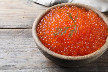 Lezzetli kırmızı havyarlı kase ve ahşap masada dereotu.