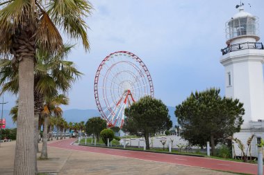 BATUMI, GEORGIA - MAY 31, 2022: Beautiful street with lighthouse and Ferris wheel
