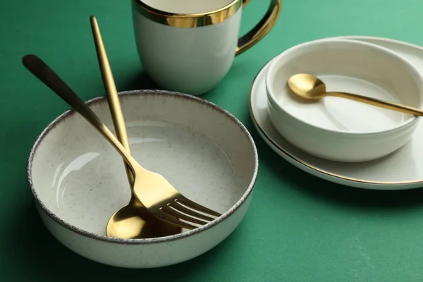 Стильная Пустая Посуда Золотые Столовые Приборы Зеленом Фоне — стоковое фото