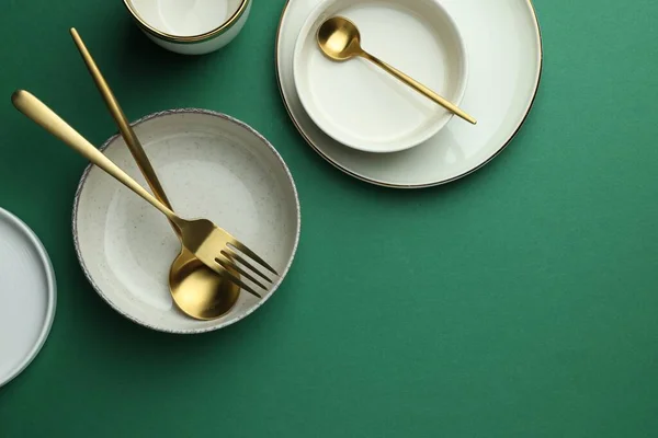 Stylish Empty Dishware Golden Cutlery Green Background Flat Lay Space — Zdjęcie stockowe