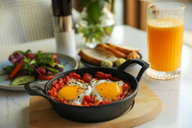 Lezzetli Shakshouka beyaz masada servis yapıyor. Geleneksel Arapça yemek