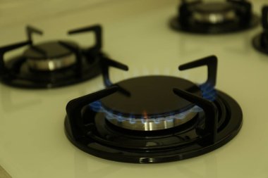 Modern sobanın gaz ocağı, yanan mavi alev, yakın çekim.