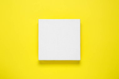 Blank canvas on yellow background, top view. Space for design