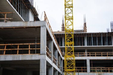 Construction site with tower crane near unfinished building