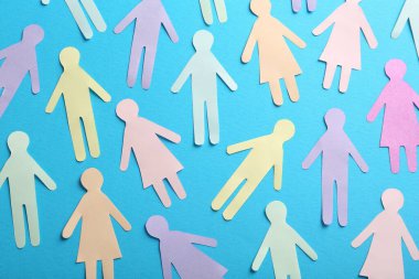 Many different paper human figures on light blue background, flat lay. Diversity and inclusion concept